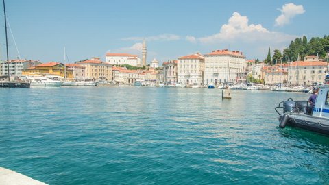 PIRAN, SLOVENIA - 7. AUGUST 2018 A white boat is slowly approaching the harbor. It's a nice summer day in the sea town of Piran.
