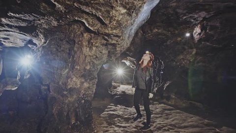 The girl speleologist and her friends walk in an underground cave
