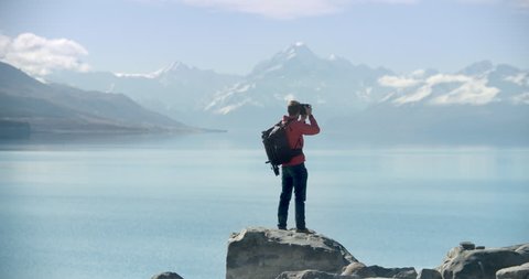 Travel blogger taking photographs in New Zealand. Lake with Mt Cook in background. Video clip recorded on professional camera, 10bit Pro Res in slo-motion.