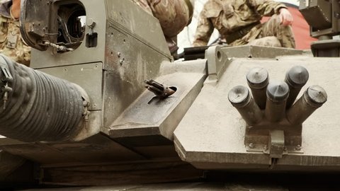 Close-up of a group of soldiers on top of the turret of a war tank