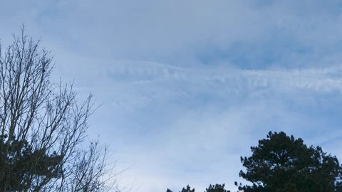 Short Timelapse of sky in British park with clouds, planes and vapour trails.