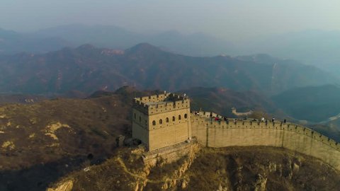 Great Wall of China and Green Mountains in Smog at Sunset. Badaling. Aerial View. Drone is Orbiting