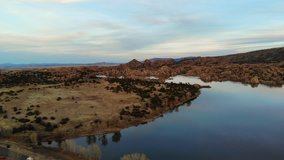 Aerial pan shot of Watson Lake in Prescott Arizona. Very high up with little winds and slightly cloudy. Nearing sunset time.
