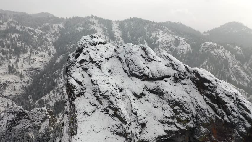 Chilling aerial scene of a solitary mountain peak blanked in snow and captured in 4K footage. Perfect for storytelling, themed presentations or quality B-Roll edits.