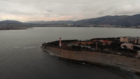 Aerial panorama of lighthouse on thousand of Gelendzhik city, sea resort at black sea for summer travel and tourism, coastline from above view, toned