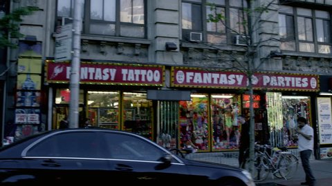 NEW YORK - MAY 23, 2015: Papaya Dog, fantasy sex and tattoo shops on Waverly Place, West Village, West 4th Street on 6th Ave, 4K NY. Greenwich Village is a neighborhood in Manhattan, NYC, USA.