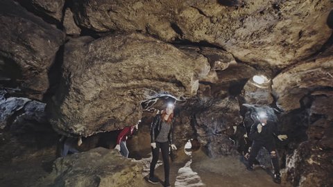 A couple of speleologists are exploring a cave.
