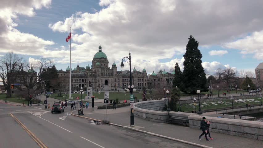 Wide shot of Victoria parliament from moving vehicle, sunny day