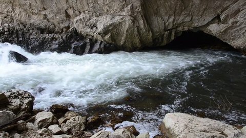River disappears into a cave. Subterranean river. River enters the underground. Disappearing karst water. Ponor. Cascading water. Underground river flowing through its cave system. Sinkhole