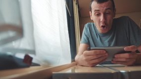 man playing an online game on a smartphone, strong emotions, anger man sitting in a train by the window. lifestyle slow motion video. train emotions joy surprise journey concept - Powered by Shutterstock - Get 15% off with code: PIKWIZARD15