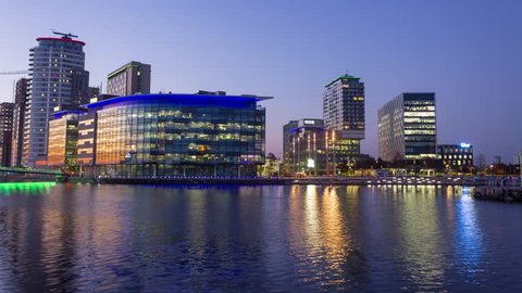 Timelapse overlooking Salford MediaCity Manchester BBC buildings at sunset day to night.