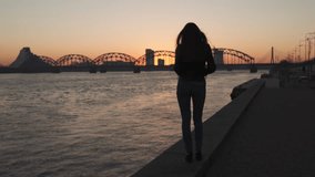 Young woman feeling confident during a lifestyle walk along the River Daugava at a sunset