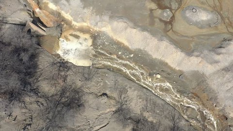 Mining drainage and polluted  river stream 4K aerial video