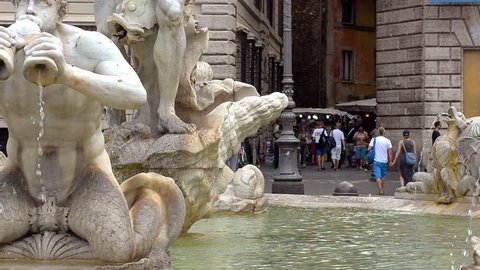 Rome, Italy - June , 2016: Turisti passeggiano alle spalle della Fontana del Moro, Moor fountain located at the southern end of Piazza Navona, it represents a Moor, Neptune surrounded by four Tritons