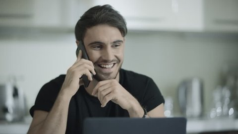 Happy business man talking phone at home. Happy businessman using mobile phone at kitchen. Portrait of smiling professional have conversation on smartphone. Handsome person talk cellphone