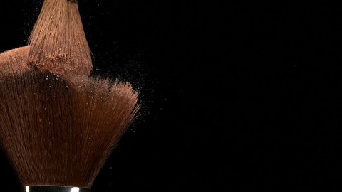 Make-up Brush spreading blush powder on black background, Slow motion