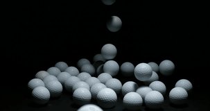 Golf's Balls falling against Black background, slow motion 4K