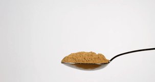 Ginger, Zingiber officinale, Powder falling on a Spoon against White Background, Slow Motion 4K