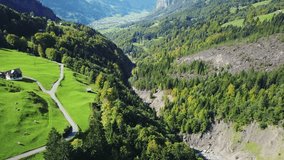 Aerial view of deep valley with wild river. Smooth and stabilized footage from drone flying above landscape. Swiss alps in Europe.