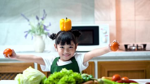 Asian kid in the kitchen at home. Kid enjoy cooking the healthy food with variety of vegetable.