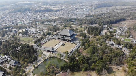 Aerial Drone Footage of Sakura (Cherry Blossom) Trees in Todaiji (Todai-Ji) Temple, Daibutsu-Den, Nara Park, Kagamiike (Kagami-Ike) Pond, Kasugano Park, Nara, Japan.