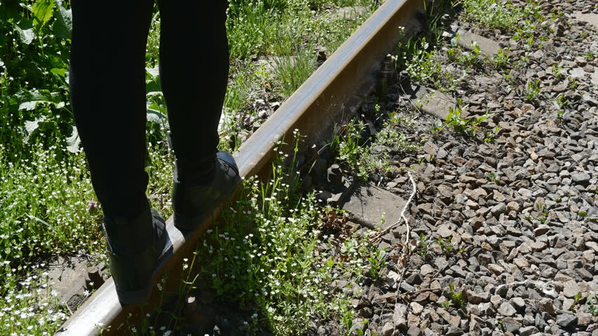 Girl tourists walk on the tracks at the train station.tavel concept.