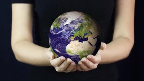 Young woman holds realistic Earth in her hands. Element of this video furnished by NASA