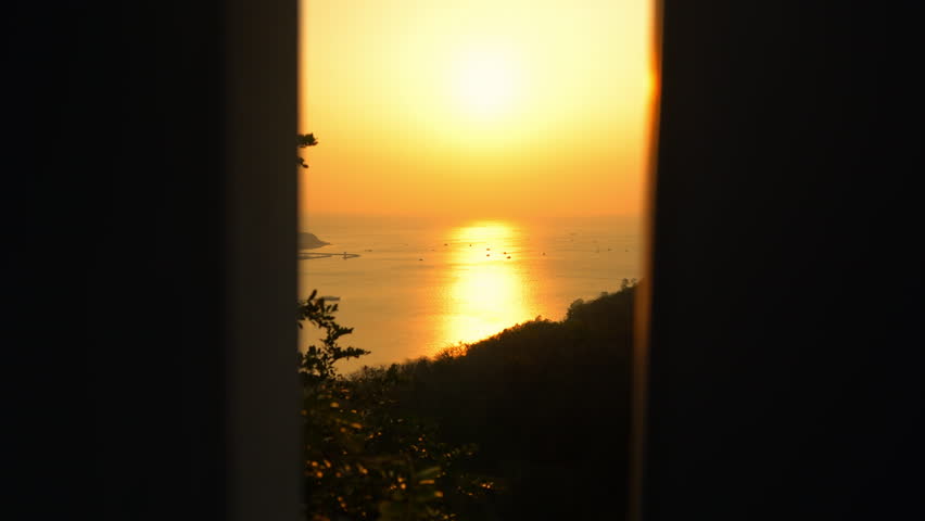 Gorgeous sunset sky over Sanya resort in China. Panoramic view of calm sea waves.