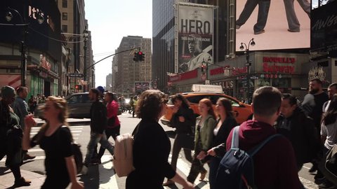 New York, NY / USA - April 6, 2019: Hectic urban scene on 34th street and 8th avenue. Crowds of people crossing the street in Midtown Manhattan New York City.