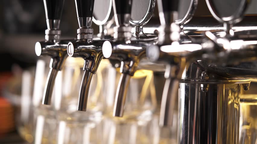 Bartender pouring draft beer in the bar. Close-up demonstration video. Beer is poured into a glass. | Shutterstock HD Video #1027945670