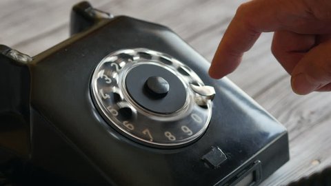 Elderly Man Dialing A Number On A Vintage Retro Black Rotary Phone