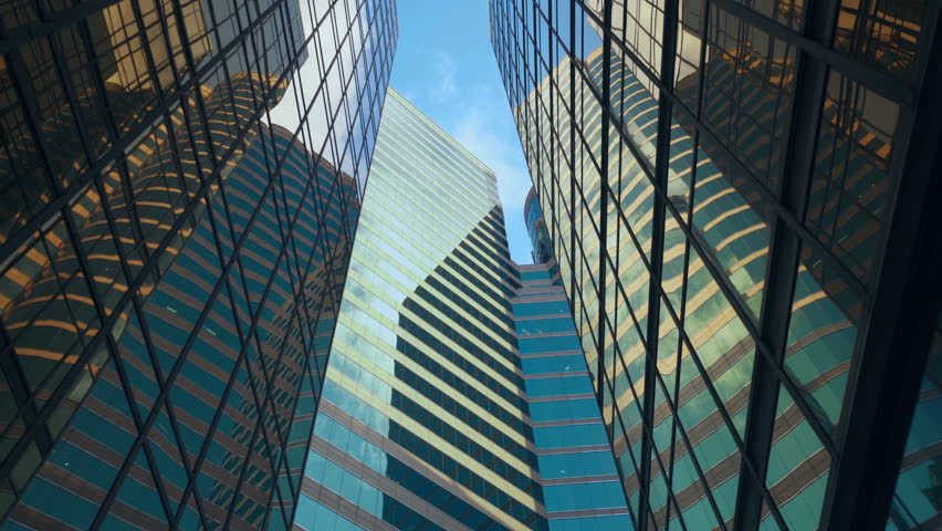 Modern skyscrapers in business district against blue sky. Office buildings with reflection of clouds | Shutterstock HD Video #1027962380