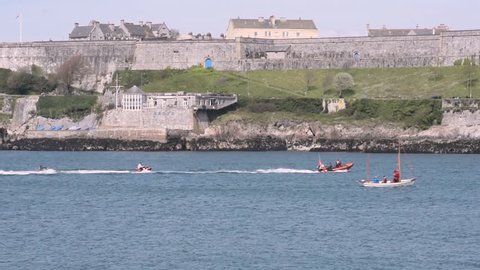 Assortment of Water Craft Passing Plymouth Royal Citadel including jet skis, sailing dinghy’s , speed boats, inflatables and one crane heavy duty buoy lifting tug barge launch platform. Plymouth Devon