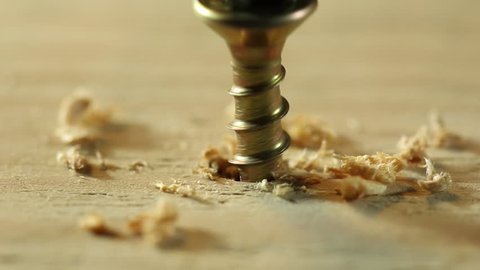 Extreme close up of drilling into wood with screw twisted into place.