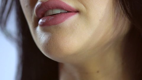 Girl lips macro extreme close up with lipstick talking saying speaking word. Female woman lips close up says, slow motion saying word. mouth teeth. woman's girl's lips, speech. Sexy lips with Botox