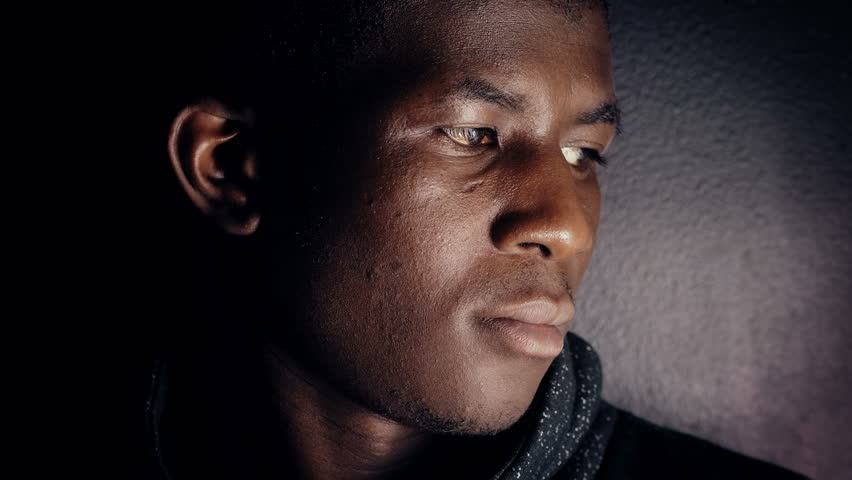 Pensive confident young american african man in dark,turning and looking camera