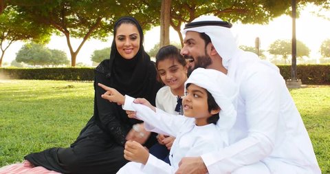 Happy muslim family spending weekend time at the park in Dubai