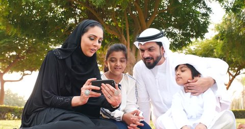 Happy muslim family spending weekend time at the park in Dubai