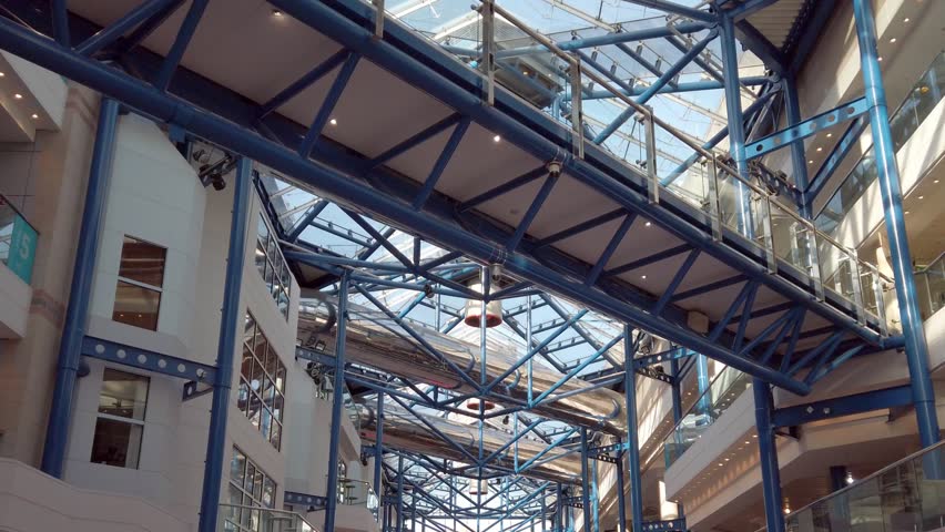 Building atrium roof made from glass and steel.
Tracking shot of atrium interior looking up at the roof structure.