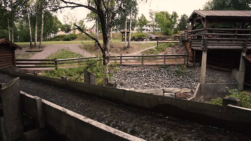 Water going through old wooden river mill in slow motion