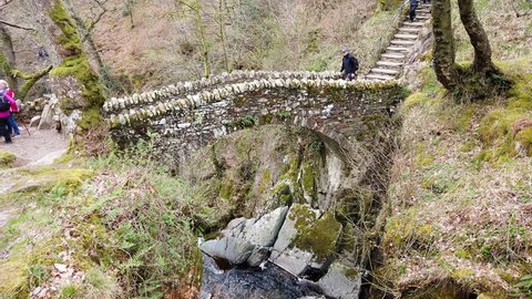 LAKE DISTRICT, UK - APRIL 9, 2019: Stone bridge at the top of the Aira Force waterfall in the Lake District National Park in Cumbria, UK.