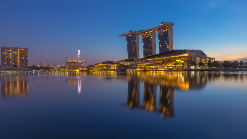 Beautiful Time lapse of Night to Day of Singapore city skyline with reflection at dawn. Zoom out motion timelapse. Royalty-Free Stock Footage #1027997015