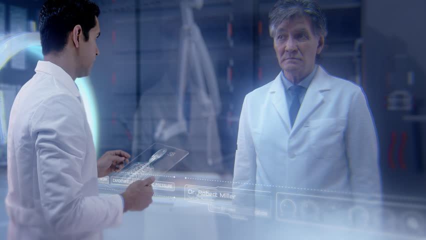 Two doctors having an online video conference analyze a patient's medical MRI diagnosis by checking on a large glass screen with futuristic holograms. Concept of: medicine, doctors, future, holography Royalty-Free Stock Footage #1028003162