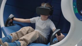 Boy enjoying virtual reality attraction using VR headset in a moving interactive chair