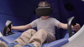 Little boy playing virtual reality in a moving interactive chair
