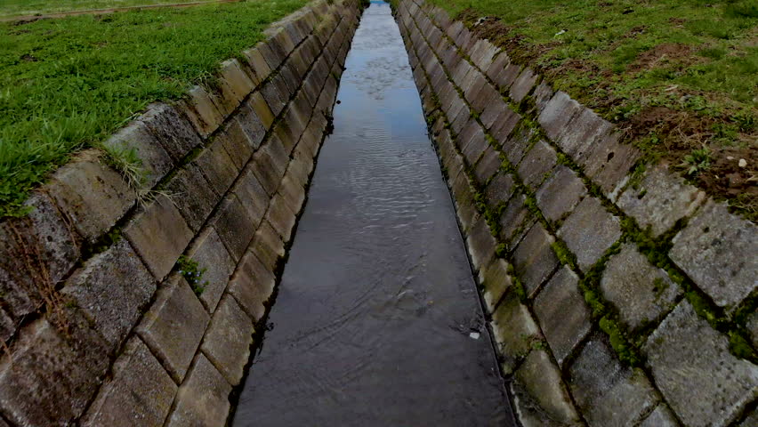Low angle follow shot of a ditch during daytime