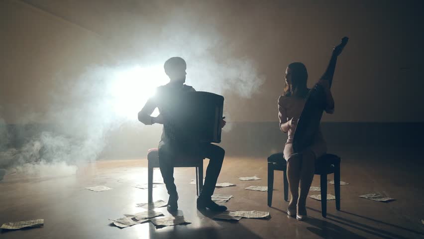 Musicians silhouettes playing and falling sheets, smoke on background in slowmo