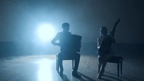 Musicians silhouettes playing and falling sheets, smoke on background in slowmo