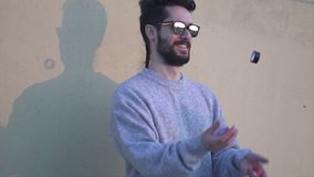 Juggler, Young Man wearing Sunglasses  Juggling  in Slow Motion video shot with gimbal