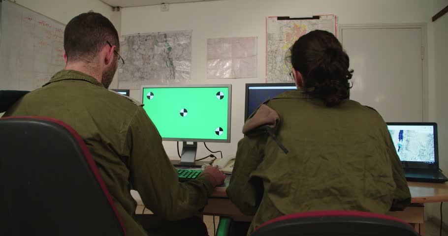 Israeli soldiers in a military command and control room looking at screens